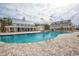 A wide shot shows the vast community pool alongside a beautifully constructed building with a metal roof under cloudy skies at 8079 Laurel Ash Ave., Myrtle Beach, SC 29572