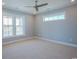 Serene bedroom with neutral carpet, a ceiling fan, and large windows offering views of the community lake at 8125 Living Tide Dr., Myrtle Beach, SC 29572