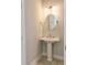 Compact powder room with a pedestal sink, a round mirror, and sconce lighting at 8156 Living Tide Dr., Myrtle Beach, SC 29572