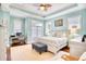 Sunlit bedroom boasts a ceiling fan, desk by the window, and a charming white wooden bed at 843 Howard Ave., Myrtle Beach, SC 29577