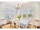 Light-filled dining room with three large windows, white chairs, and a patterned tablecloth at 843 Howard Ave., Myrtle Beach, SC 29577