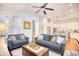 Cozy living room featuring hardwood floors, blue sofas, and an open floor plan leading to the kitchen at 843 Howard Ave., Myrtle Beach, SC 29577