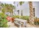Outdoor patio with a wooden table and red chairs, surrounded by lush greenery at 843 Howard Ave., Myrtle Beach, SC 29577