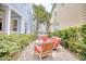 Cozy outdoor patio with comfortable red seating and lush greenery between homes at 843 Howard Ave., Myrtle Beach, SC 29577