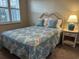 Cozy bedroom with patterned bedspread, woven headboard, and matching nightstand with lamp at 901 West Port Dr. # 1807, North Myrtle Beach, SC 29582