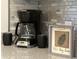 Close-up of decorative countertop decor including a coffee maker, mugs, and framed wall art at 901 West Port Dr. # 1807, North Myrtle Beach, SC 29582