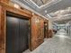 Hallway view of elevator entrances with dark doors, wood trim and marble flooring at 9650 Shore Dr. # 706, Myrtle Beach, SC 29572