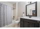 Well-lit bathroom with dark vanity, shower/tub, and decorative mirror at 10-1 Rattan Circle # 1, Pawleys Island, SC 29585