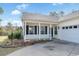 Inviting front porch with white railing and black shutters, leading to a well-lit home entrance at 10-1 Rattan Circle # 1, Pawleys Island, SC 29585