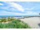 Beautiful beach scene with beach grass, wooden fence, blue umbrellas, and a sunny sky at 1105 S Ocean Blvd. # 336, Myrtle Beach, SC 29577