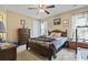 Well-lit bedroom with soft carpeting features a ceiling fan, dresser, and a comfortable bed with a decorative quilt at 1222 Midtown Village Dr., Conway, SC 29526