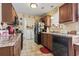 The kitchen features wooden cabinets and black appliances, plus a view to the laundry area at 1222 Midtown Village Dr., Conway, SC 29526