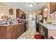 Well-lit kitchen featuring wood cabinets, black appliances, and adjacent laundry area at 1222 Midtown Village Dr., Conway, SC 29526