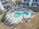 Aerial view of the outdoor swimming pool with lounge chairs and tables in a fenced-in patio area, great for relaxing or entertaining at 131 Greenside Villas Dr. # B10, Little River, SC 29566