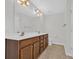 Bathroom with a double sink vanity, dark wood cabinets, a large mirror, and modern fixtures at 145 Goldenrod Circle # 7B, Little River, SC 29566