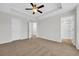 A bright bedroom featuring a ceiling fan, neutral walls, carpet flooring, and an ensuite bathroom at 145 Goldenrod Circle # 7B, Little River, SC 29566