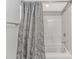 Clean bathroom with a shower-tub combo featuring white tile and a shower curtain with floral design at 1819 Ocean Blvd. N # 1403, North Myrtle Beach, SC 29582