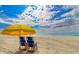 Picturesque beach view featuring blue beach chairs under a sunny, cloud-filled sky at 1819 Ocean Blvd. N # 1403, North Myrtle Beach, SC 29582