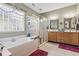 Well-lit bathroom with a separate tub and glass shower, double sinks, and a decorative chandelier at 1822 Topsail Ln., North Myrtle Beach, SC 29582