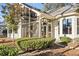 Home exterior featuring a screened-in porch and patio surrounded by lush landscaping and mature trees at 1822 Topsail Ln., North Myrtle Beach, SC 29582