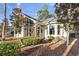 Rear exterior view of home featuring a screened-in porch, brick patio, and landscaped yard with mature trees at 1822 Topsail Ln., North Myrtle Beach, SC 29582