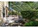 Charming back porch with lattice railing and a cozy seating area, shaded by lush greenery at 2120 Adams Way, Little River, SC 29566