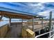 A covered wooden pier featuring benches, railings, and scenic views of the water and horizon at 2120 Adams Way, Little River, SC 29566