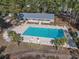 Aerial view of a community pool with lounge chairs surrounded by mature trees at 2120 Adams Way, Little River, SC 29566