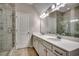 Bright bathroom featuring double sinks with white countertops and a glass-enclosed shower at 223 Gloucester Way, Little River, SC 29566