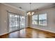 Dining area features hardwood floors, a sliding glass door to the balcony, and a stylish chandelier at 223 Gloucester Way, Little River, SC 29566