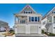 Charming two-story home with gray siding, white trim, and a two-car garage offers timeless curb appeal at 223 Gloucester Way, Little River, SC 29566