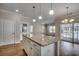 Kitchen island features granite countertop and white cabinets with hardwood floors at 223 Gloucester Way, Little River, SC 29566