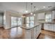 Open kitchen with island, white cabinets and a slider door to the porch at 223 Gloucester Way, Little River, SC 29566