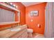 Orange bathroom featuring a sink with a granite countertop, toilet, and shower with curtain at 2402 N Ocean Blvd., North Myrtle Beach, SC 29582