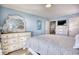 Light blue bedroom with large dresser and a doorway leading to another room with a television at 2402 N Ocean Blvd., North Myrtle Beach, SC 29582