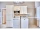 Well-lit laundry area with white washer and dryer, cabinets, and a microwave on a shelf at 2402 N Ocean Blvd., North Myrtle Beach, SC 29582