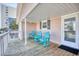 Covered front porch featuring three blue rocking chairs with a white door and side window at 2402 N Ocean Blvd., North Myrtle Beach, SC 29582