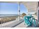 Charming ocean view porch features a bright blue table and stools for enjoying the outdoors at 2402 N Ocean Blvd., North Myrtle Beach, SC 29582