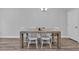 Dining area featuring a wooden table with modern white chairs set against a neutral wall, creating a simple and stylish space at 2475 Blue Crane Circle # 103, Myrtle Beach, SC 29577