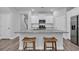 Kitchen island featuring a gray granite countertop, with wooden stools, and white cabinets, perfect for cooking and entertaining at 2475 Blue Crane Circle # 103, Myrtle Beach, SC 29577