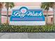 Eye-level view of the Bay Watch Resort & Conference Center sign, with colorful flowers and palm trees at 2701 S Ocean Blvd. # 1009, North Myrtle Beach, SC 29582