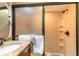 Modern bathroom featuring granite countertop, a glass shower, and a round mirror at 311 69Th Ave. N # 404, Myrtle Beach, SC 29572