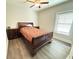 Bedroom featuring wood-look floors, a ceiling fan, a bed with red floral pattern bedspread and two nightstands at 311 Las Olas Dr., Myrtle Beach, SC 29577