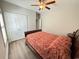 Bedroom with a ceiling fan, a bed with red floral pattern bedspread, a closet and grey wood-look floors at 311 Las Olas Dr., Myrtle Beach, SC 29577