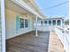 Large wooden deck offering a fantastic view and space for outdoor activities, with white railings at 317 23Rd Ave. N, North Myrtle Beach, SC 29582