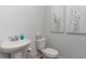 Simple half bathroom with a pedestal sink, a white toilet, and modern artwork on the wall at 348 Rookroost Circle, Conway, SC 29526