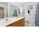 Well-lit bathroom with double sinks, framed mirror, and a shower/tub with a floral curtain at 3567 Chestnut Dr. # 3567, Myrtle Beach, SC 29577