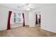 Bright bedroom featuring neutral carpet, a ceiling fan, and a window with red curtains at 3567 Chestnut Dr. # 3567, Myrtle Beach, SC 29577