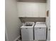 Bright laundry area features a full-sized washer, dryer, and white cabinets for plenty of storage space at 372 Leste Rd., Myrtle Beach, SC 29588