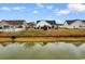 Backyard view of the home from across the pond, showcasing a serene waterfront setting at 401 Barton Loop, Myrtle Beach, SC 29579